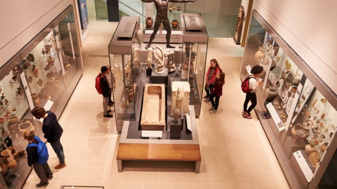 Overhead View Of Busy Museum Interior With Visitors